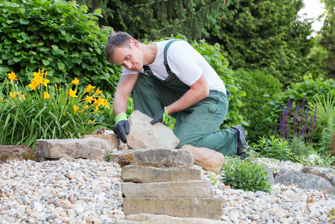Ein Landschaftsgärtner bei der Arbeit an einer Steintreppe im Garten