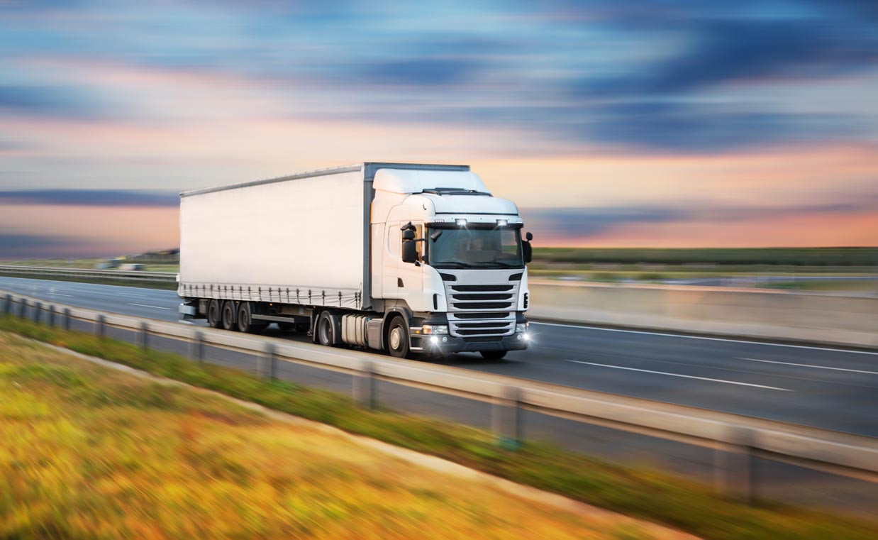 Weißer Lkw unterwegs auf der Autobahn