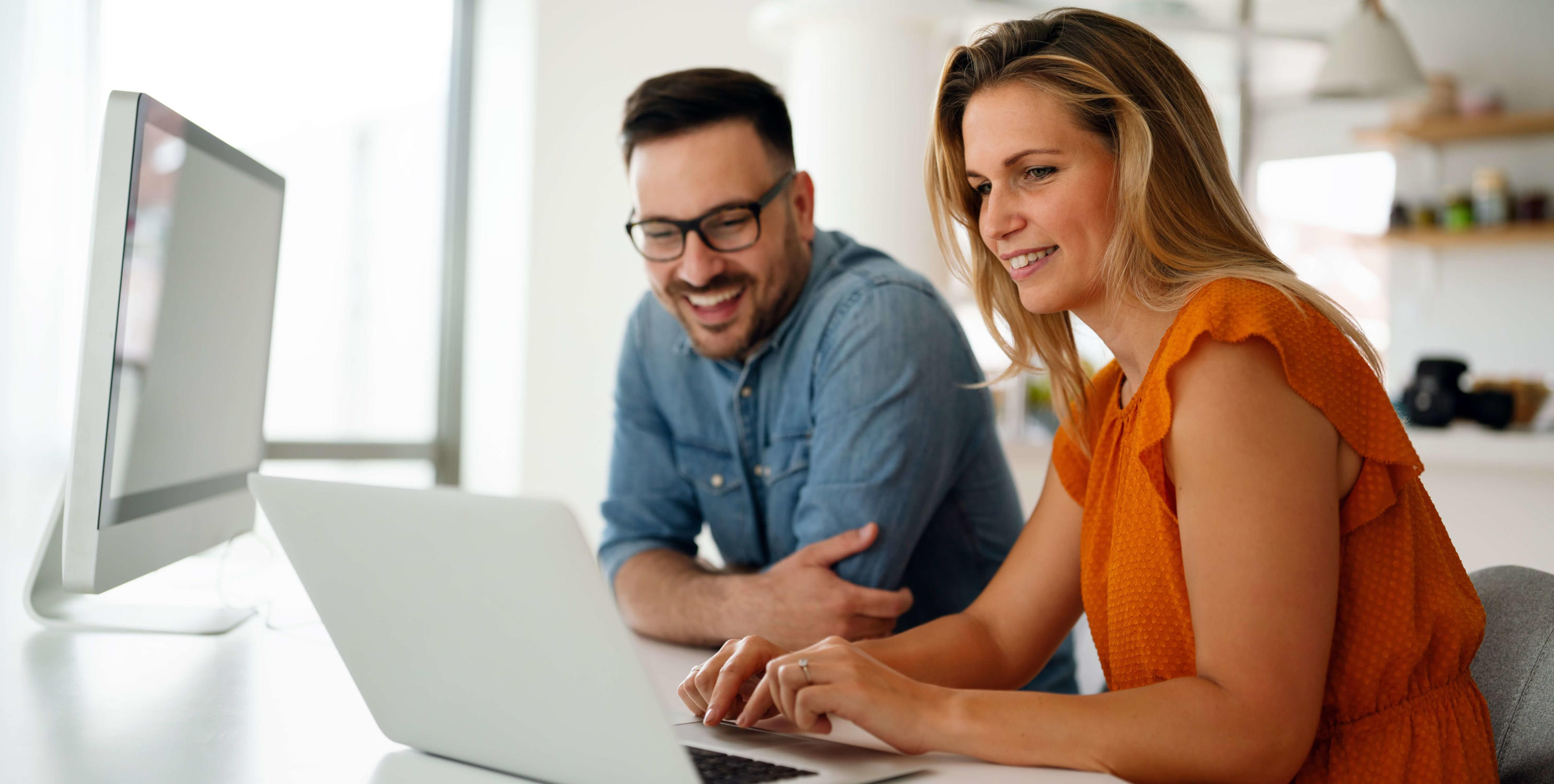 Frau und Herr, die gemeinsam am Computer arbeiten