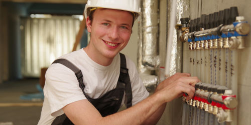 Gastechniker bei der Arbeit an Leitungen im Gebäude